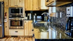 A kitchen with wooden cabinets, a stainless steel oven, a microwave, a sink, and a coffee maker. - Cozy Cabin with Beautiful Views. Minutes from Downtown Custer (Custer)