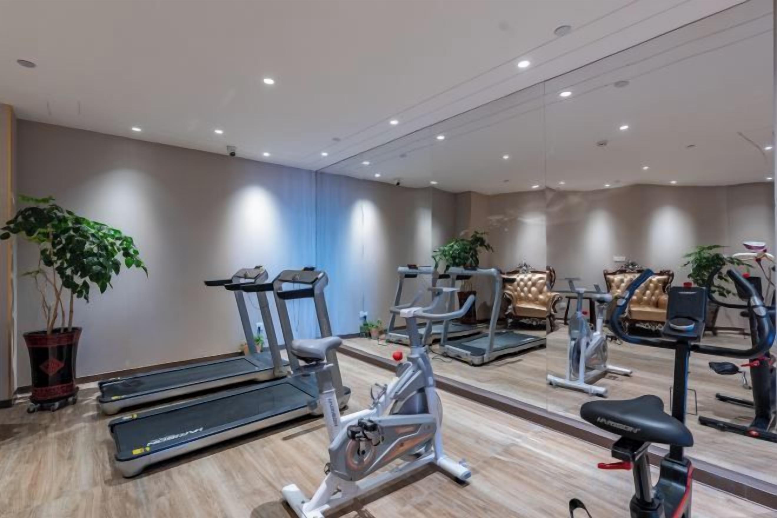 A gym with treadmills, stationary bikes, and exercise equipment.