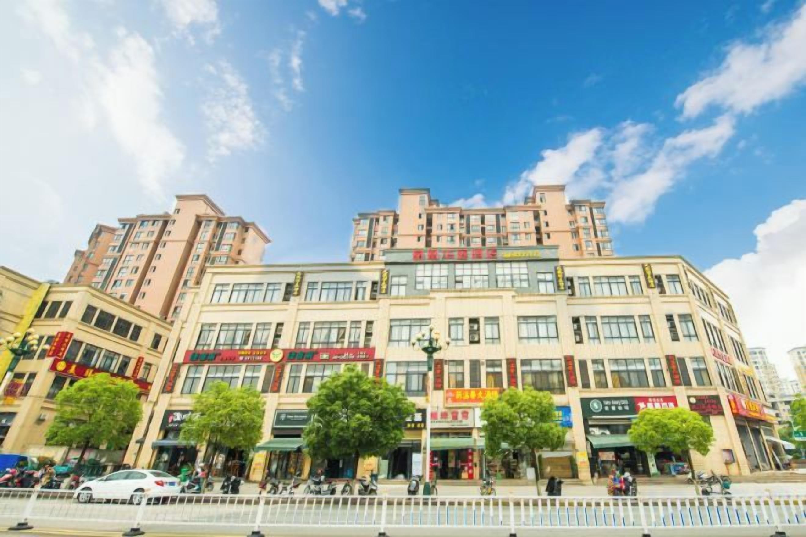 Un edificio de varios pisos con locales comerciales en la planta baja, incluyendo tiendas y restaurantes.