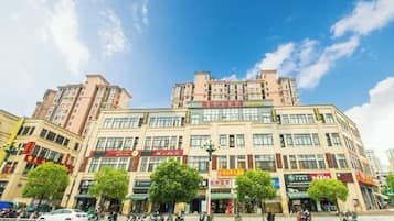 Un edificio de varios pisos con locales comerciales en la planta baja, incluyendo tiendas y restaurantes.