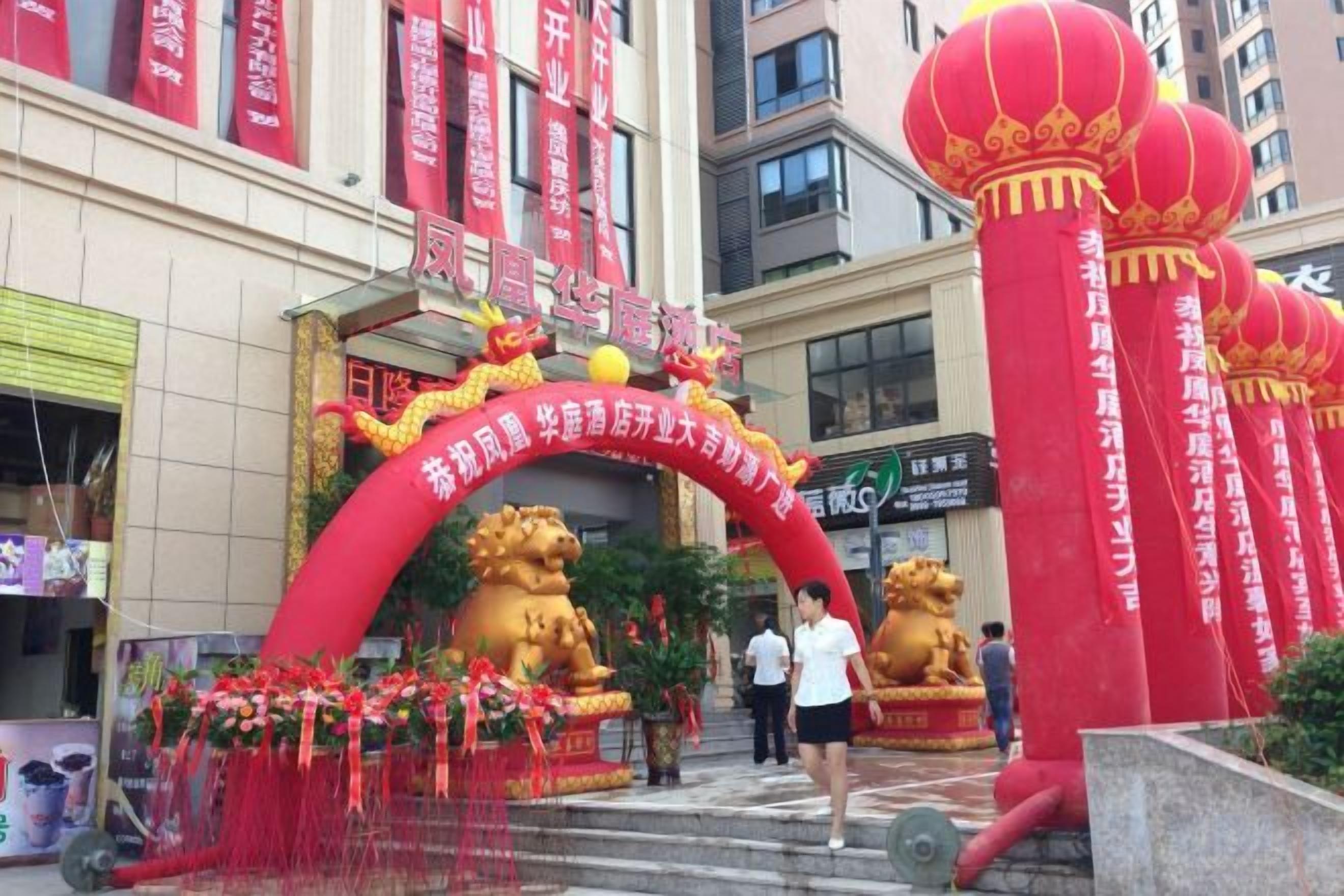 A building entrance with a red archway, golden lion statues, and red lanterns.