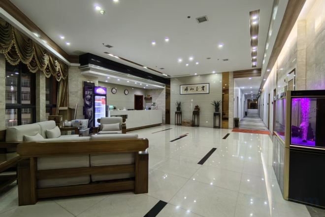 Un vestíbulo de hotel con mostrador de recepción, zona de estar y mostrador de información.