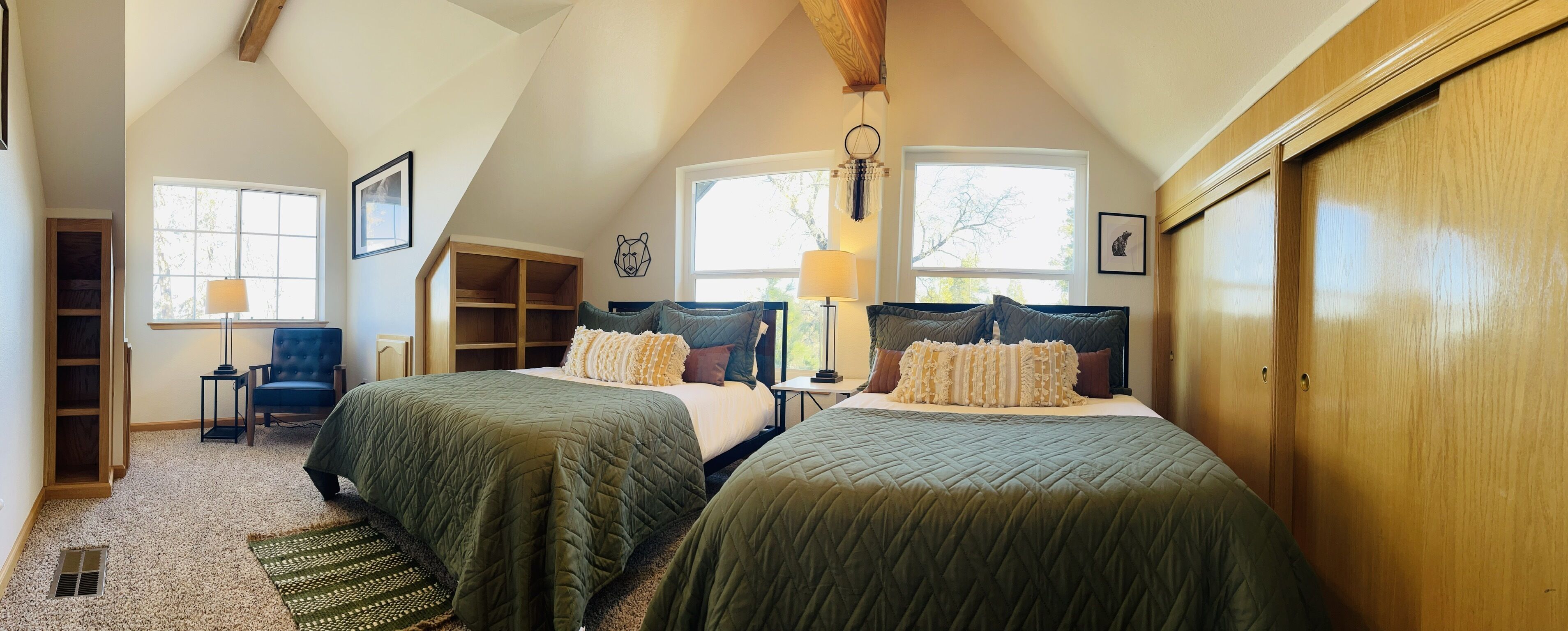 Ein Schlafzimmer mit zwei Betten, einem Schreibtisch, einem Stuhl und einem Fenster.