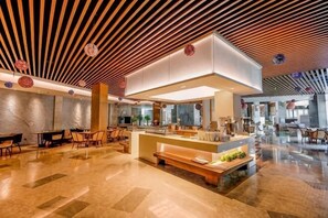 Un hall d’hôtel moderne avec un plafond en bois, un comptoir d’accueil, un espace salon et un plancher poli.