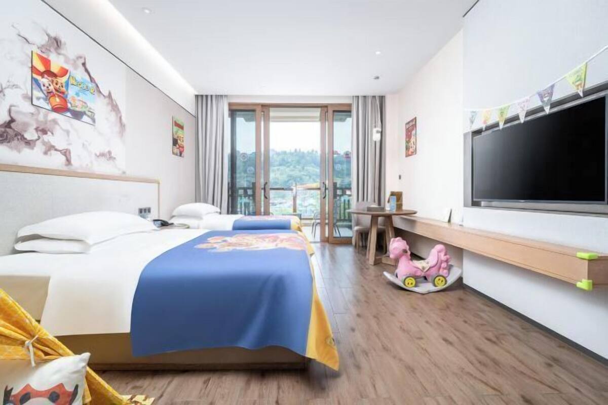 Una habitación de hotel con cama, televisión, escritorio y ventana con vistas.