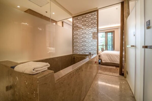 A modern bathroom with a marble sink, a towel, and a view into a bedroom. - Shiqian Fodingshan Hot Spring Town Yutangsheng Hot Spring Resort Hotel (Shiqian)