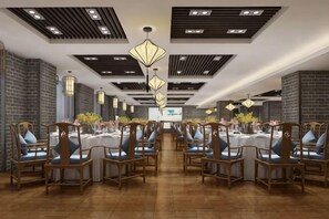 A conference room with round tables, chairs, and a projector screen. - Qingchuang Hotel (Ziyang)
