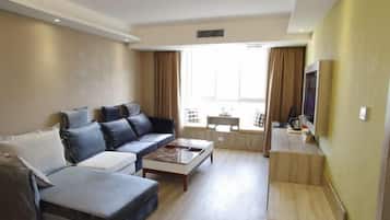 A modern living room with a sofa, a coffee table, and a TV.