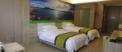A hotel room with two beds, a desk, and a painting of a landscape on the wall.
