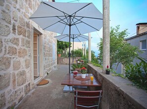 Enjoy a peaceful outdoor retreat with a patio featuring a table, chair, and lush greenery.
