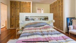 Ein Schlafzimmer mit einem großen Bett, einem Holzschrank und einem kleinen Nachttisch.