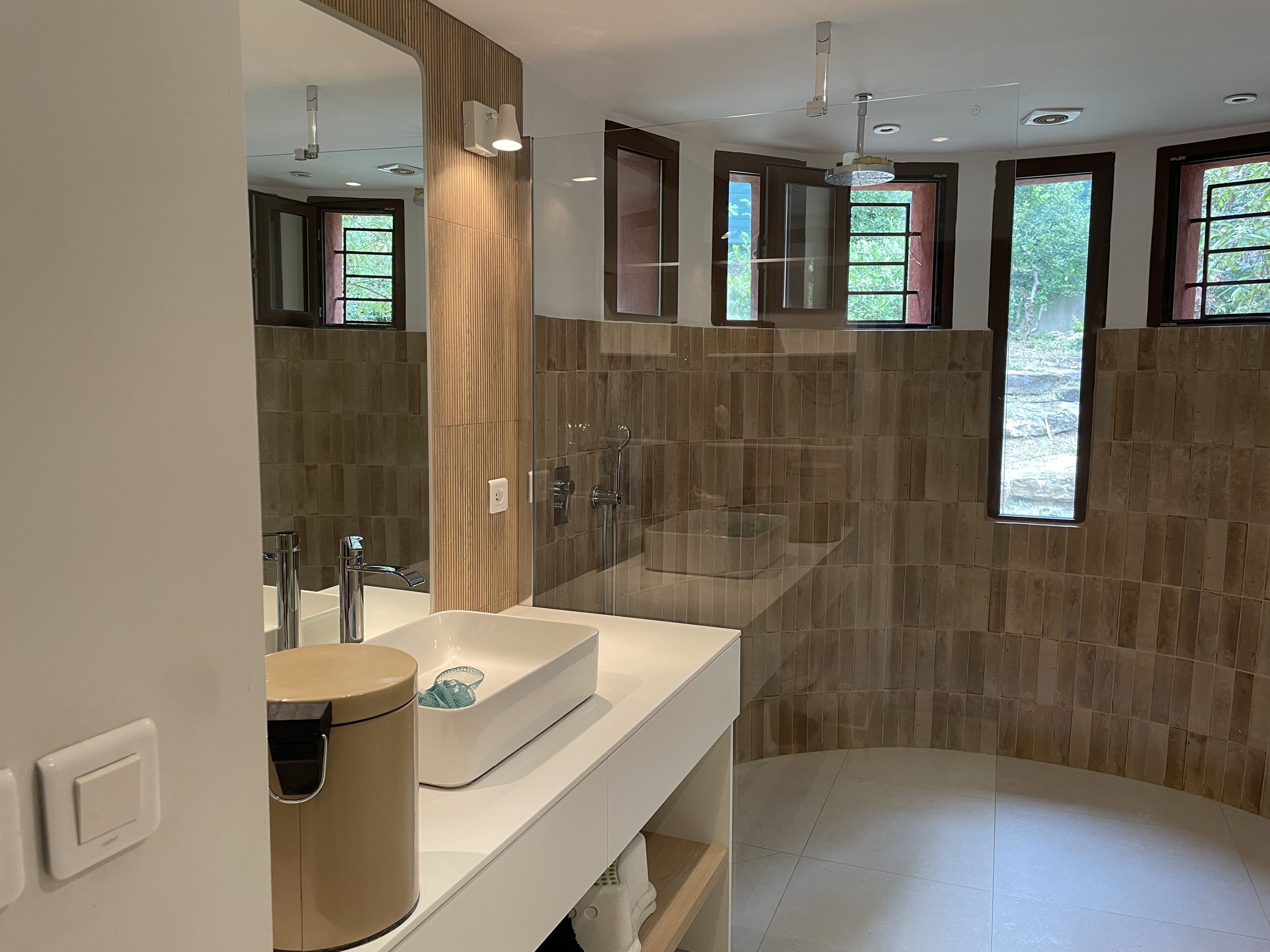 Une salle de bain moderne avec un grand miroir, deux lavabos, une douche et des toilettes.