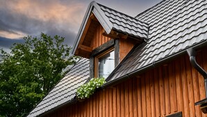 A wooden building with a sloped roof and a dormer window.