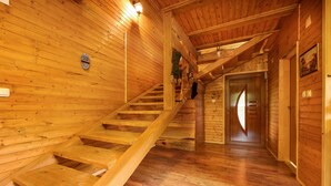 A wooden interior with a staircase leading to a door.