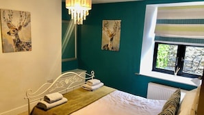 Una camera da letto con un letto, un lampadario, opere d'arte e una finestra vista.