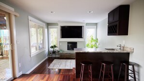 A modern kitchen with a large island, bar stools, and a flat-screen TV. - ♠️ Lake View ♠️ Private ♠️ Centrally Located ♠️ Spacious ♠️ Fast Wifi (Renton)