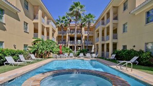A hotel with a swimming pool surrounded by lounge chairs and palm trees. - Blue Ocean Vacation Rentals at Las Verandas️ ️ (South Padre Island)