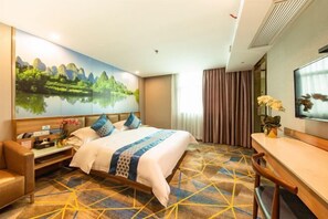 A hotel room with a bed, a desk, a chair, a TV, and a painting of a landscape. - Boli Yiju Hotel (Kai Pingmu Village) (Kaiping)