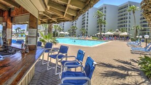 Ein Poolbereich mit Liegestühlen, einer Bar und einem Pool.