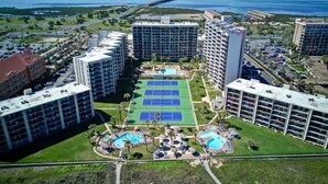 Ein Hotelkomplex mit mehreren Gebäuden, einem Tennisplatz und einem Schwimmbeckenbereich.