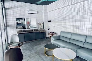 Un interior moderno con una kitchenette, un sofá y una mesa de centro redonda.