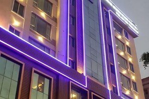 A multi-story building with illuminated vertical lines and windows.