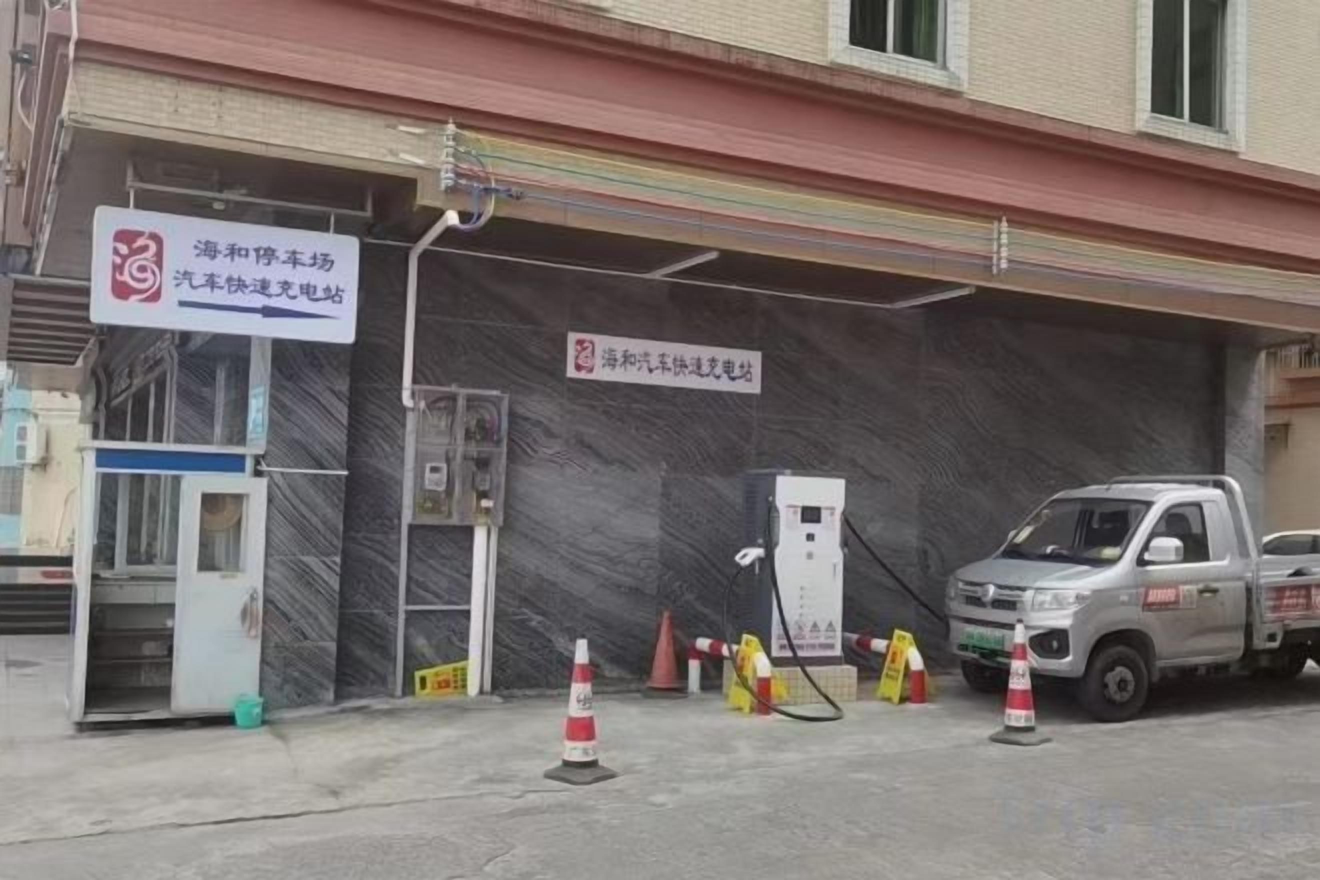 Une station-service avec un camion garé, une pompe à essence et un panneau indiquant une zone de services.