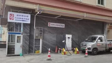 Une station-service avec un camion garé, une pompe à essence et un panneau indiquant une zone de services.