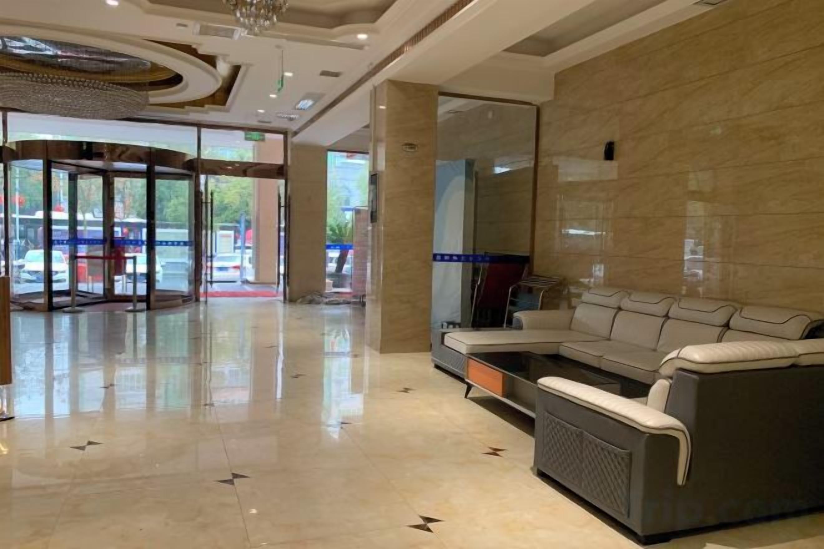 A hotel lobby with a seating area, a glass door entrance, and a modern interior design.