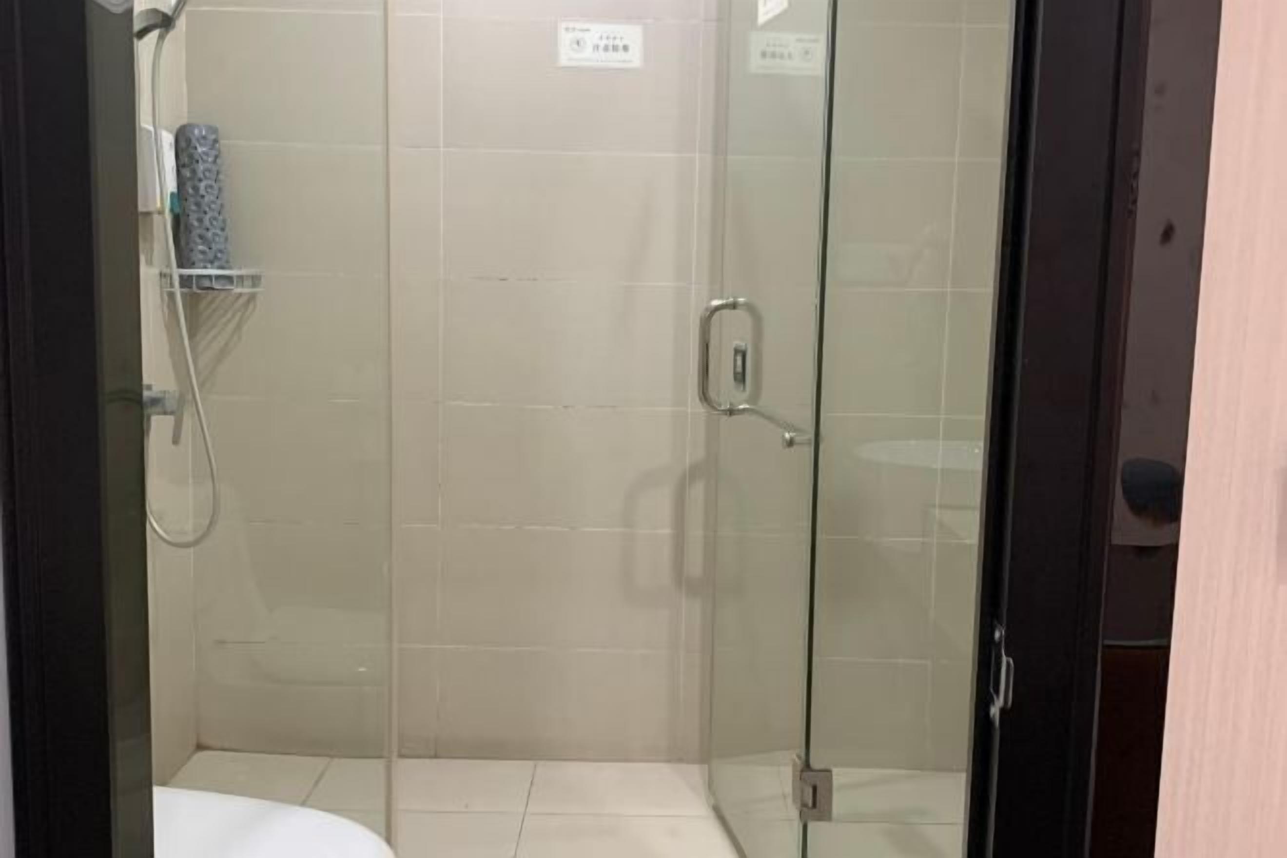 A glass-enclosed shower area with a toilet visible in the foreground.