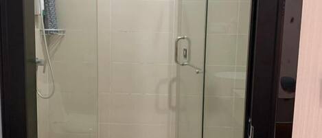 Eine gläserne Duschkabine, im Vordergrund ist eine Toilette zu sehen.