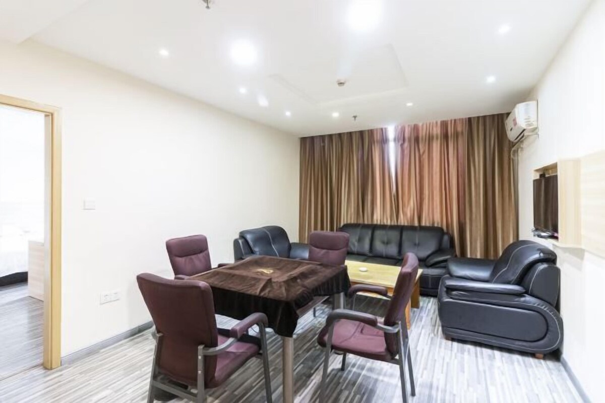 A conference room with a table and chairs, a sofa, and a curtain backdrop.