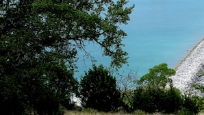 A coastal landscape with a clear view of the sea and a gravel beach. - Romantic Cabin: Hot Tub, Pet friendly, 2m Whitewater, Concierge, Private driver (Canyon Lake)