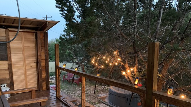 A wooden deck with a bench and a hot tub. - Romantic Cabin: Hot Tub, Pet friendly, 2m Whitewater, Concierge, Private driver (Canyon Lake)