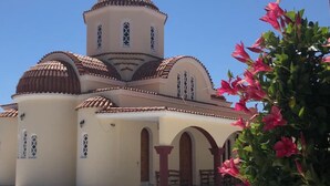 Eine Kirche mit einer zentralen Kuppel und kleineren Kuppeln, Bogenfenstern und einem Glockenturm.