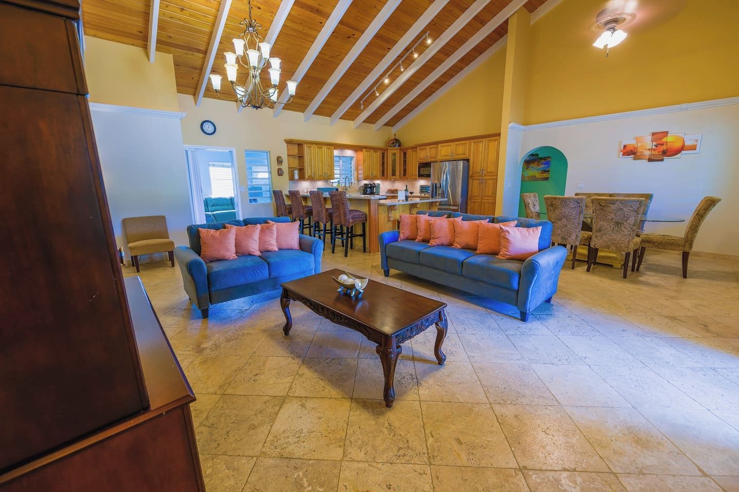 A spacious living area with two sofas, a coffee table, and a dining area with chairs and a table.
