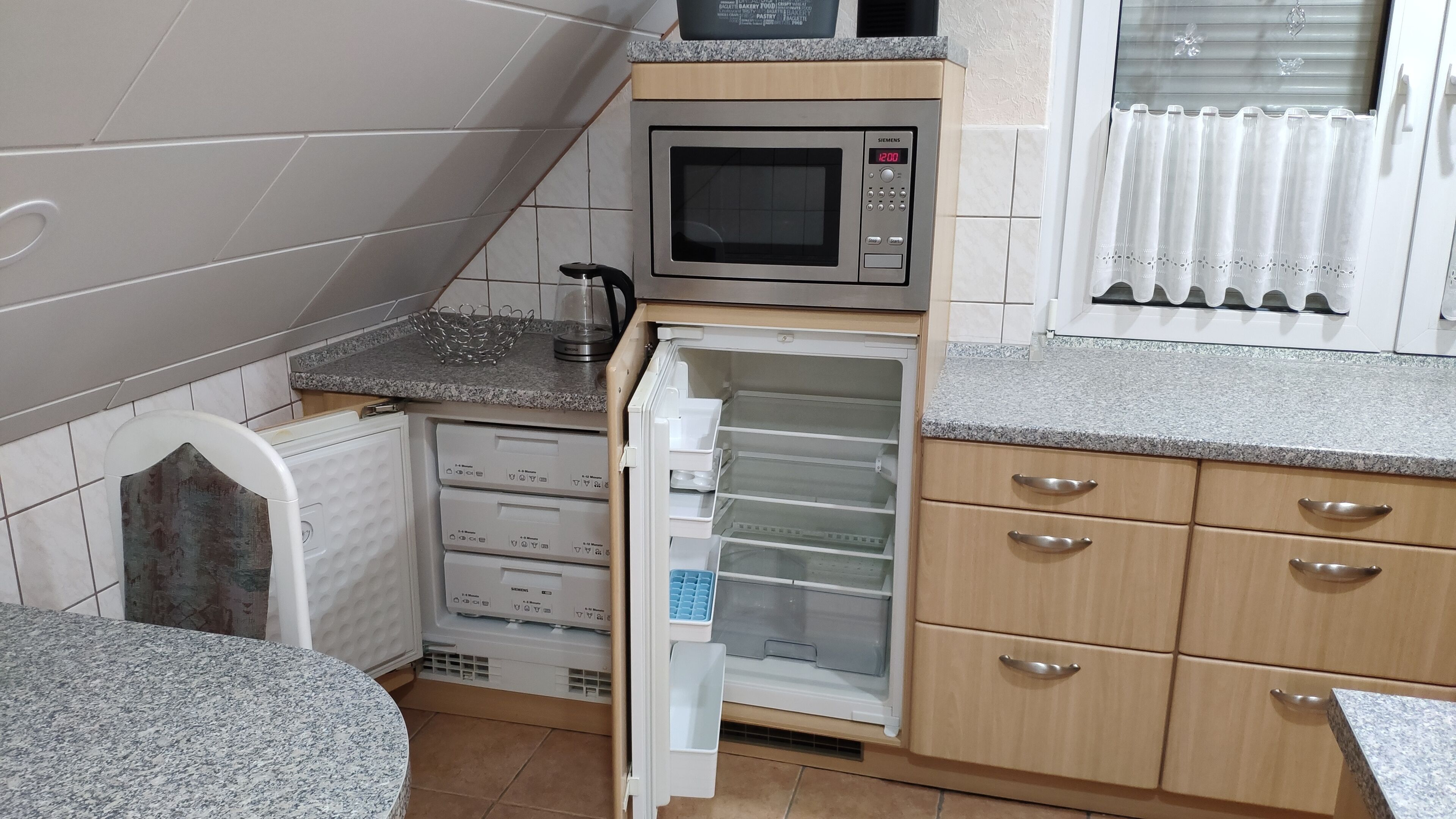 Une cuisine compacte équipée d’un four à micro-ondes, d’un réfrigérateur et d’un évier.