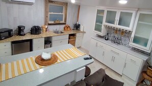 A compact kitchen with a central island, white cabinetry, and a microwave.