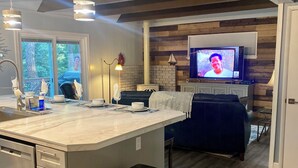 A modern kitchen with a large island, stainless steel appliances, and a built-in trash can.