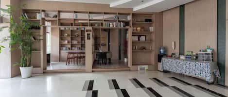 A modern interior with a central open space, a dining area, and a kitchen area with a bar.