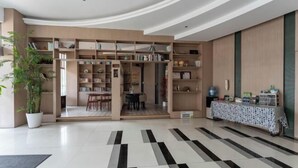 Un interior moderno con un espacio central abierto, rodeado de estanterías y una zona de comedor.