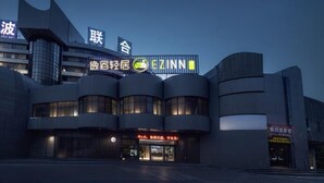 Un edificio moderno con fachada curva y señalización iluminada.