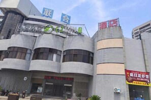 A building with a modern architectural style, featuring a curved facade and multiple levels. - Yisu Qingju Hotel (Ningbo Beilun Xiaogang) (Ningbo)