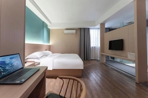 A modern hotel room with a bed, a desk with a laptop, a TV on a stand, and a window with curtains. - Yisu Qingju Hotel (Ningbo Beilun Xiaogang) (Ningbo)