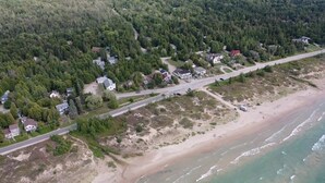 An aerial view of a coastal area with a road, houses, and a beach.