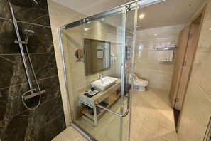 Une salle de bain moderne avec une douche à parois de verre, un lavabo et des toilettes.