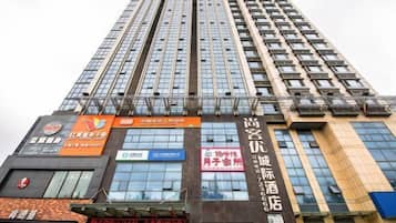 A high-rise building with multiple commercial establishments on its lower floors, including a restaurant, a convenience store, and a hotel.