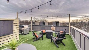 An outdoor patio with a barbecue grill, seating area, and string lights. - Johnny Cash House • Walk to Bars & Dining (Nashville)