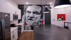A modern kitchen with white cabinets, a stainless steel refrigerator, a microwave, and a black pendant light. - Johnny Cash House • Walk to Bars & Dining (Nashville)
