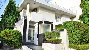 Un edificio moderno con fachada blanca, un balcón y un letrero que dice 